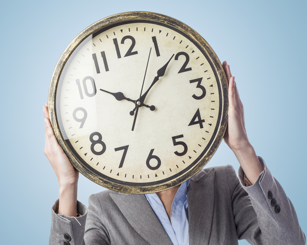 portrait of a business young woman holding a clock in front of her face